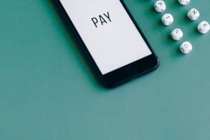 Telemóvel com a palavra PAY no ecrã, sobre fundo verde