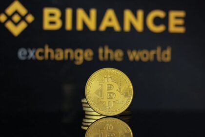 Logótipo da Binance e moedas de bitcoin