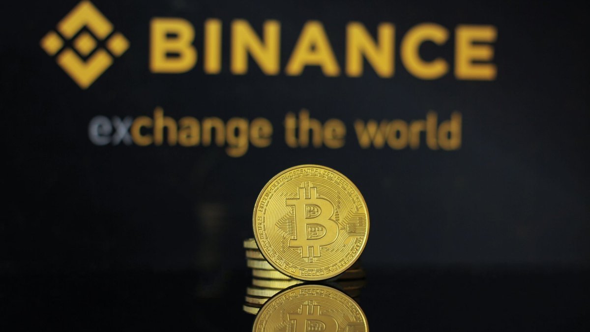 Logótipo da Binance e moedas de bitcoin